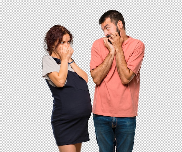 Couple with pregnant woman is a little bit nervous and scared putting hands to mouth