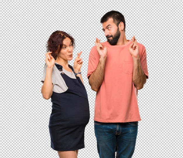 Couple with pregnant woman with fingers crossing and wishing the best