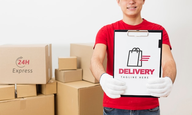 PSD courier holding clipboard in front of parcels mock-up