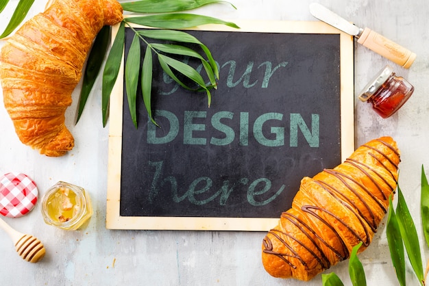 Croissant and jam with leaves palm, chalk board  flat lay mockup