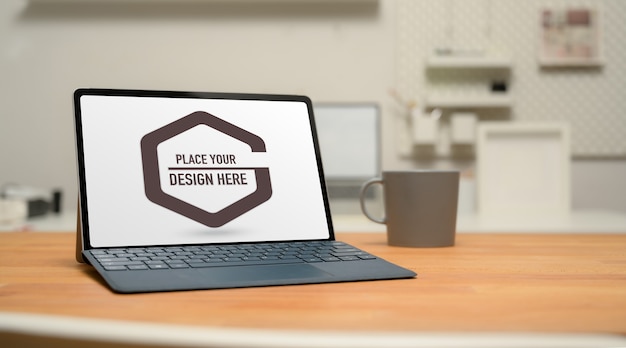 PSD cropped shot of mock up digital tablet with keyboard, coffee mug and copy space on wooden table