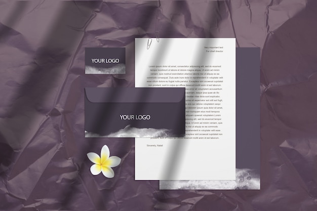 PSD mockup vuoto scuro con biglietti da visita viola, buste isolato sulla superficie con fiori e ombre. lo smart layer di psd può muoversi