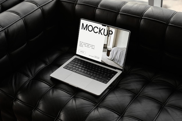 Dark digital laptop photo mockup top view on black leather couch sofa psd