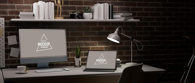 dark working space in apartment with red brick wall blank laptop and tablet screen for your brand