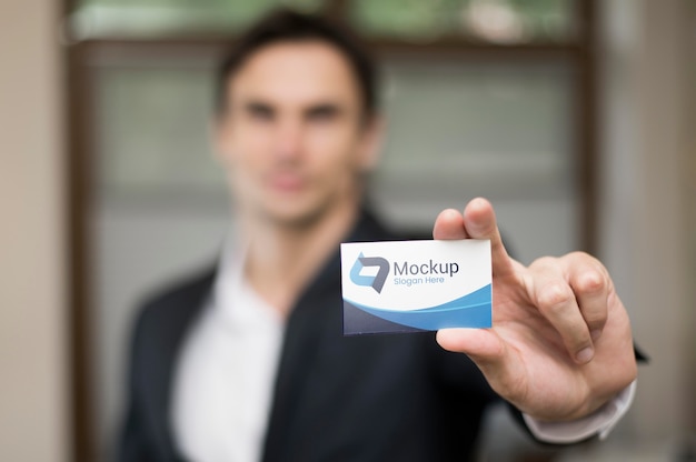 PSD defocused businessman holding business card