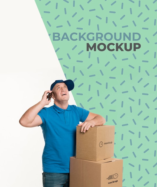 delivery man talking on the phone next to a bunch of boxes