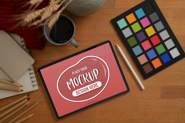 Area di lavoro di design con tablet mockup, controllo colore e caffè