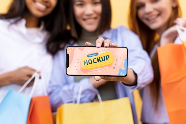 Different beautiful women holding a smartphone mock-up