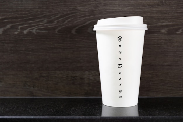 コーヒーショップのテーブルの上の使い捨てのホットコーヒーカップ