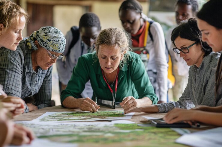 PSD diverse group of people collaborates around a large map engaging in serious discussion and planning