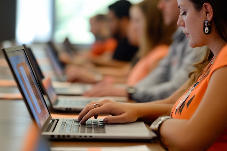 PSD diverse group of people working on laptops in a classroom or seminar setting