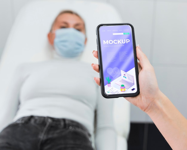 doctor holding phone mock-up near patient