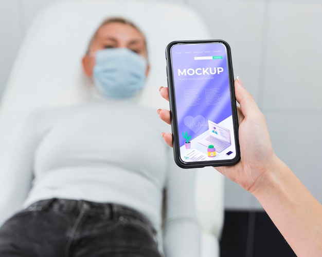 Doctor holding phone mock-up near patient