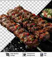 PSD doorzichtig object lam kebab gespeld op een zwarte grill vergezeld van een rode tomaat en een zwarte schaal