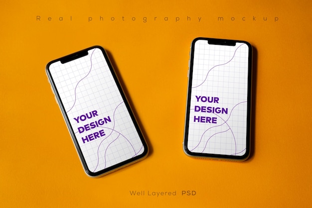 PSD double smartphone screen mockup above flat paper texture by real photography