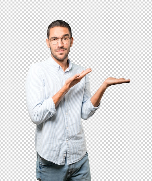 彼の手で何かを保持している疑わしい若い男