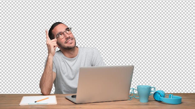 PSD doubtful young man sitting at his desk and pointing up