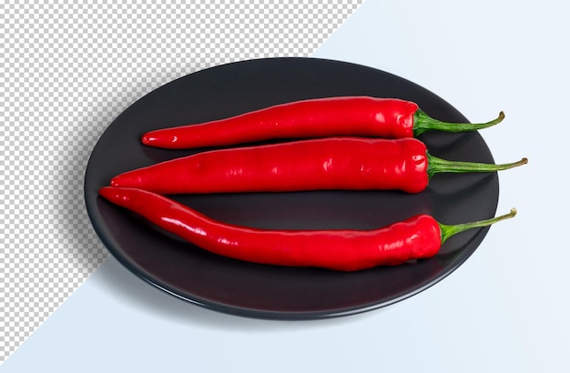 Drie rode chili's op een zwart bord.
