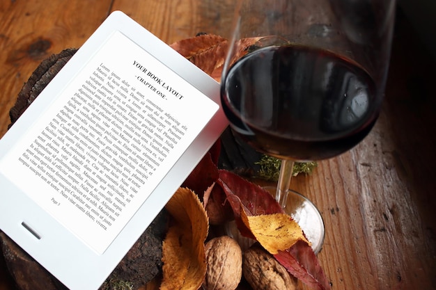 PSD e-book reader mock-up, vino rosso, fondo in legno vintage con noci, foglie autunnali