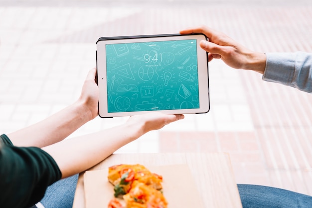 Eating couple in city with tablet