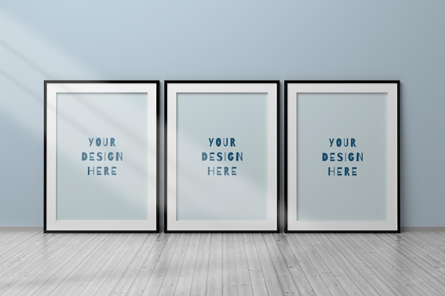 Editable psd mockup with three vertical a4 blank black frames standing on wooden floor next to wall