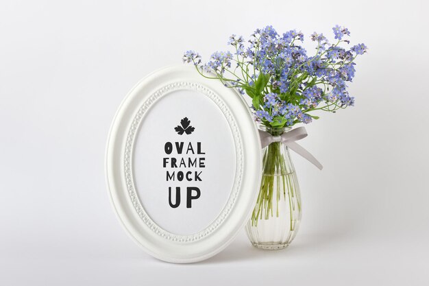 Editable psd mockup with white oval round vertical frame and blue summer flowers