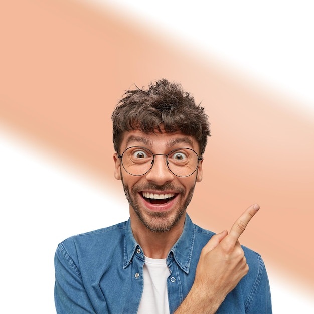 Een man met een baard en een bril maakt een grappig gezicht.