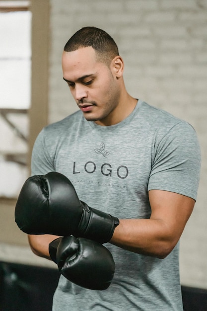een man met een grijs shirt waarop het logo staat