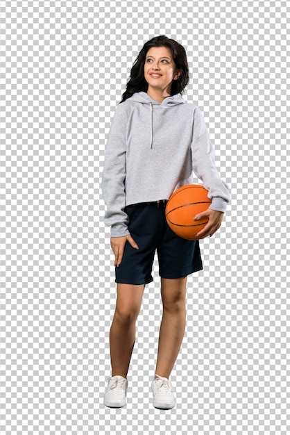 PSD een volledige lengte shot van een jonge vrouw spelen basketbal te kijken terwijl glimlachen