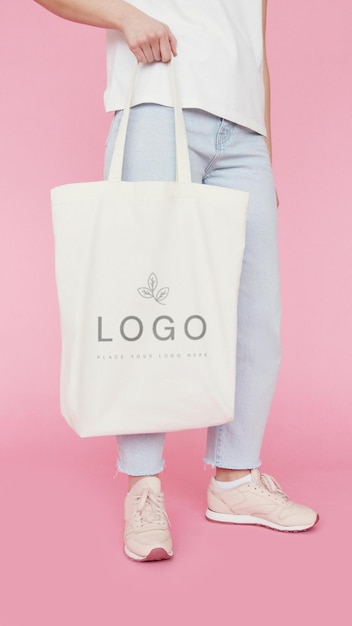een vrouw houdt een witte tas vast met het logo van het bedrijf
