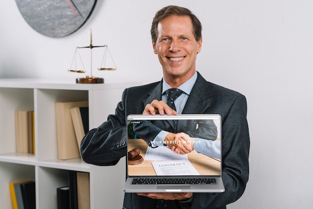 Elegant businessman presenting laptop mockup