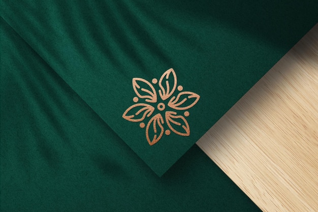 Mockup logo in rilievo con lamina di bronzo su carta verde