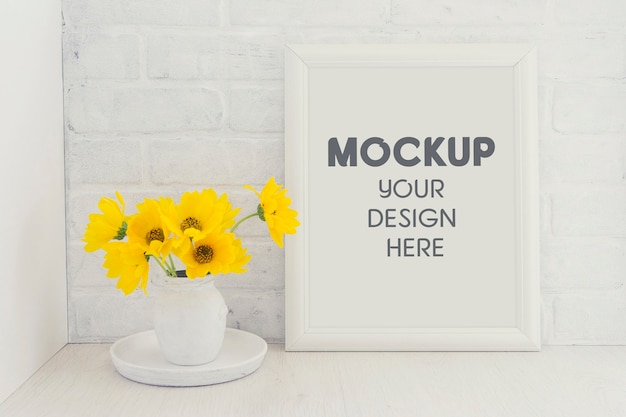 Empty white frame mockup with a bouquet of yellow sunflower flowers in a vintage vase