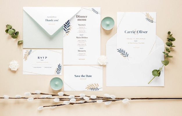Fat lay of wedding cards with plants and candles
