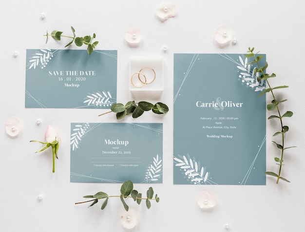 Fat lay of wedding cards with plants and rings