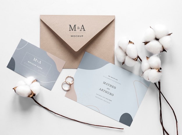 Fat lay of wedding cards with rings and cotton