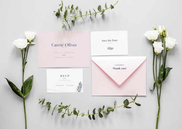 Fat lay of wedding cards with roses and plants