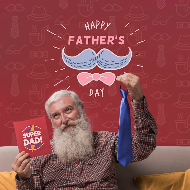 Father holding tie and cardboard mock-up on burgundy background