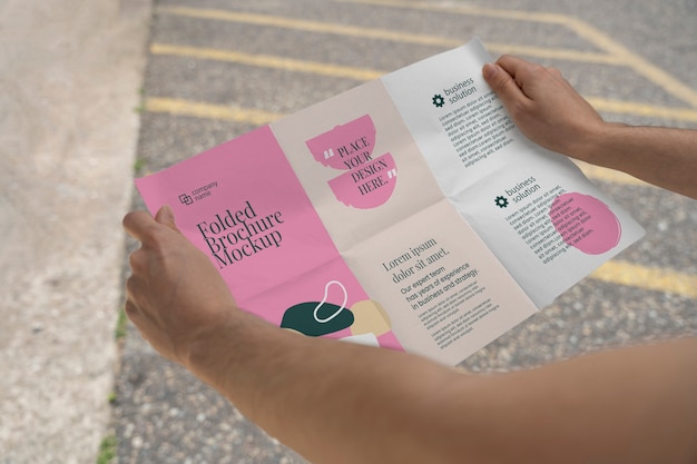 Mock-up di brochure a tre ante con mani femminili con forme astratte