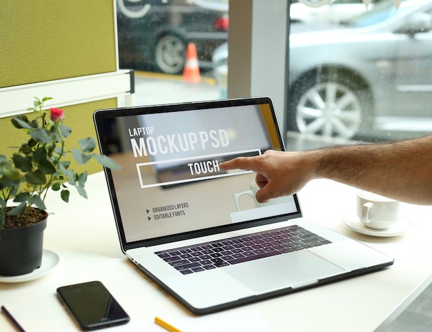 PSD finger touching to laptop in work space at office mockup psd