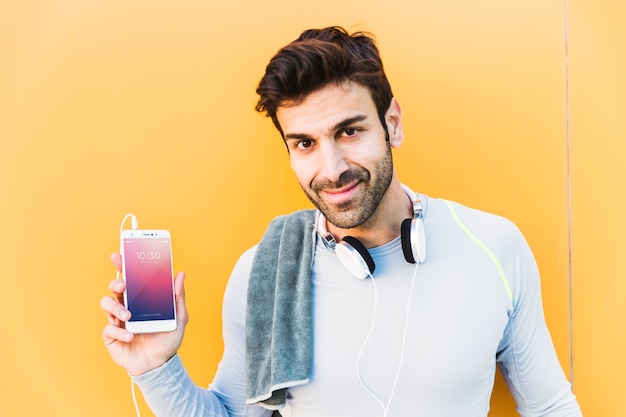 Modello di fitness con uomo che mostra smartphone