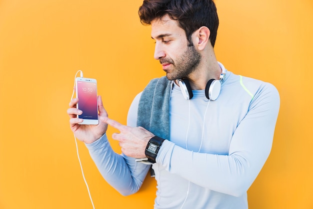 Modello di fitness con uomo che mostra smartphone