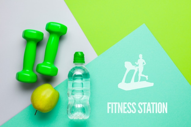 Fitness weights with water bottle and apple