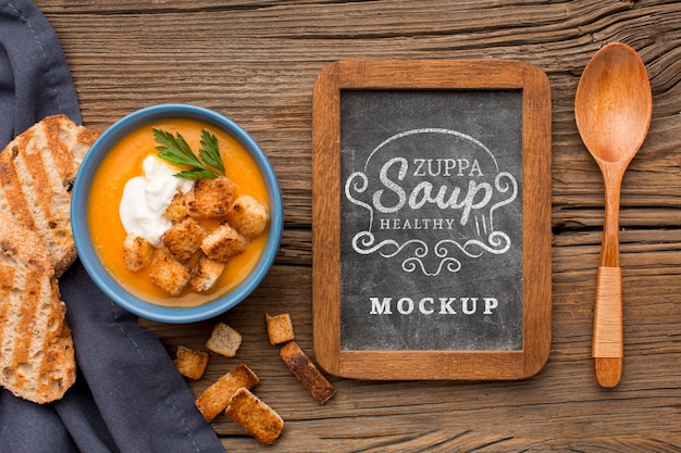 Flat lay of bowl of vegetable soup with chalkboard