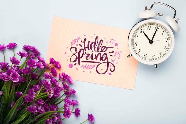 Flat lay of card with clock and flowers