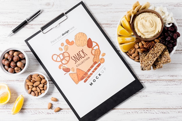 Flat lay composition of snacks with clipboard mock-up