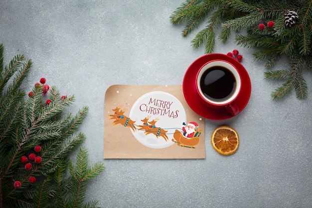 Flat lay cup of coffee with with merry christmas letter and pine leaves