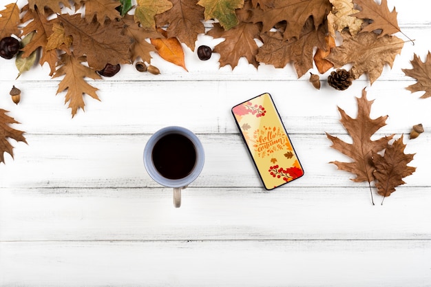 Flat lay decoration with leaves and phone