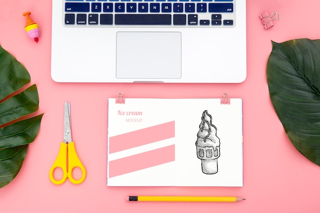 Flat lay of desk surface with laptop and leaves