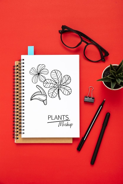 Flat lay of desk surface with notepads and glasses